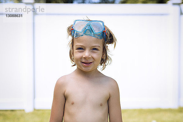 Porträt eines lächelnden Jungen mit Schwimmbrille an einem sonnigen Tag