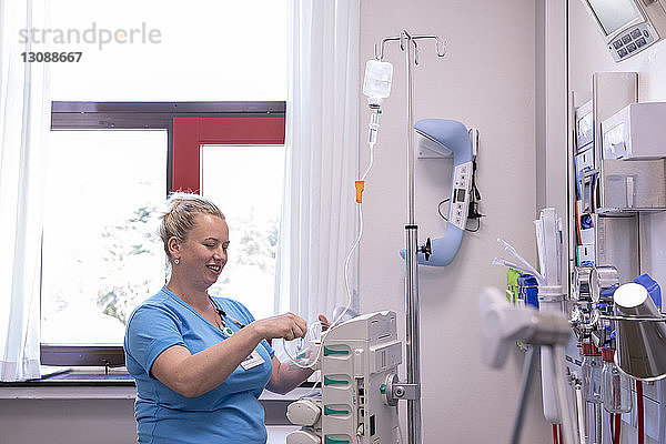 Ärztin  die im Krankenhaus stehend medizinische Geräte benutzt