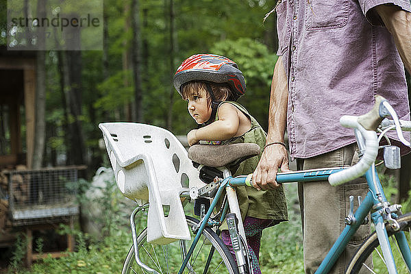 Mann mit Tochter auf dem Fahrrad im Hinterhof in der Mitte