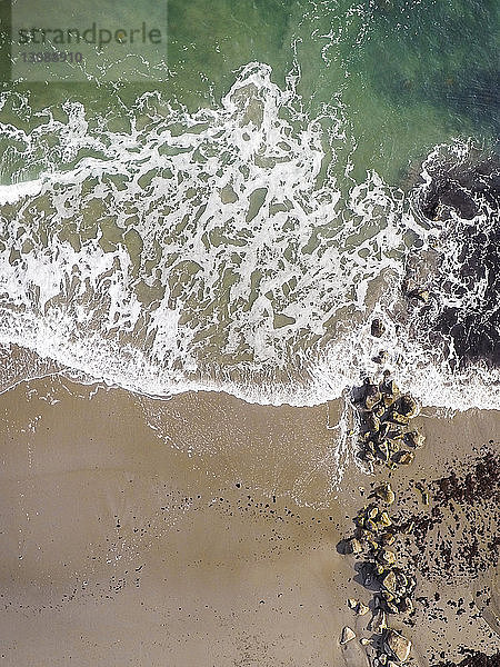 Hochwinkel-Szenenansicht der Wellen am Ufer am Strand