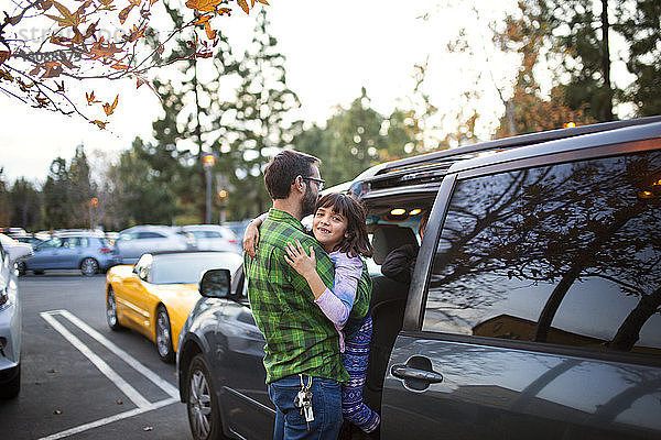 Mann mit Tochter beim Einsteigen ins Auto auf der Straße