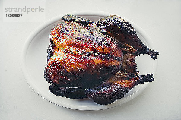 Draufsicht auf ein gebratenes Huhn  das in einem Teller auf dem Tisch serviert wird