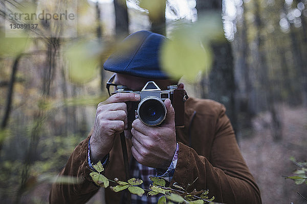 Nahaufnahme eines Mannes beim Fotografieren im Wald