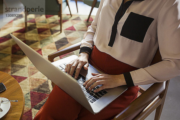 Mittelsektion einer Geschäftsfrau mit Laptop in der Hotellobby