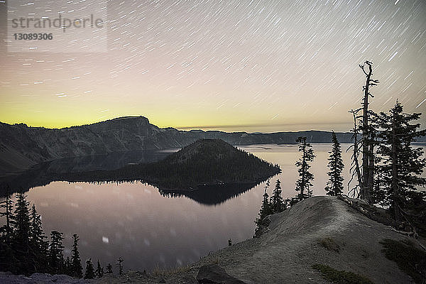 Szenische Ansicht des Sees gegen Sternenspuren am Himmel bei Sonnenuntergang