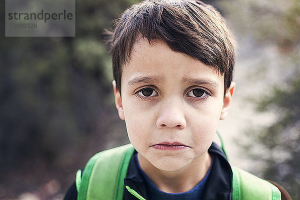 Porträt eines traurigen Jungen im Freien stehend