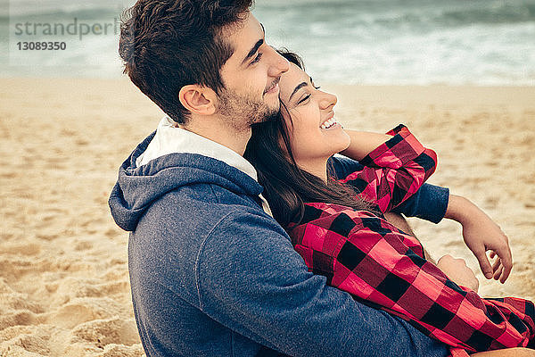 Junges lachendes Paar am Strand