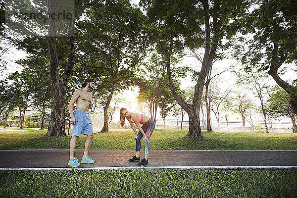 Erschöpftes Paar entspannt sich nach sportlicher Betätigung im Park