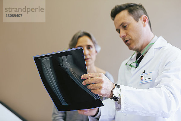 Nahaufnahme von Arzt und Patient beim Betrachten von Röntgenbildern in einer medizinischen Klinik