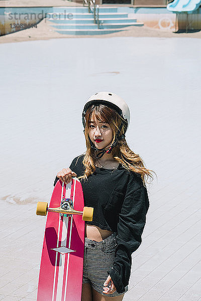 Hochwinkelporträt einer Frau mit Skateboard im Park