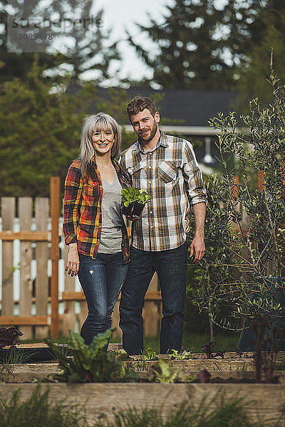 Porträt eines lächelnden Paares mit Pflanzen im Hinterhof