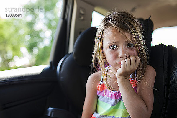 Porträt eines verärgerten Mädchens mit Fingern im Mund
