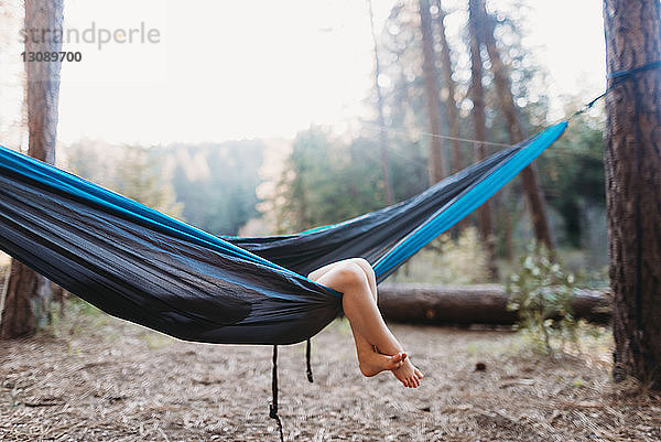 Unterer Teil des Mädchens in der Hängematte auf dem Campingplatz