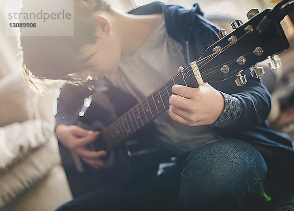 Junge spielt zu Hause Gitarre