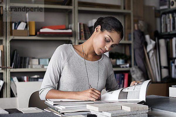 Innenarchitektin schreibt in Buch am Schreibtisch