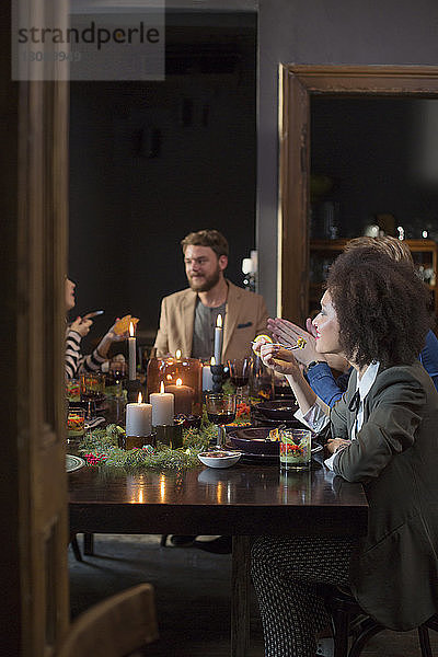 Freunde genießen das Abendessen bei Tisch zu Hause