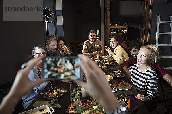 Ausschnitt einer Frau  die glückliche Freunde beim Essen fotografiert