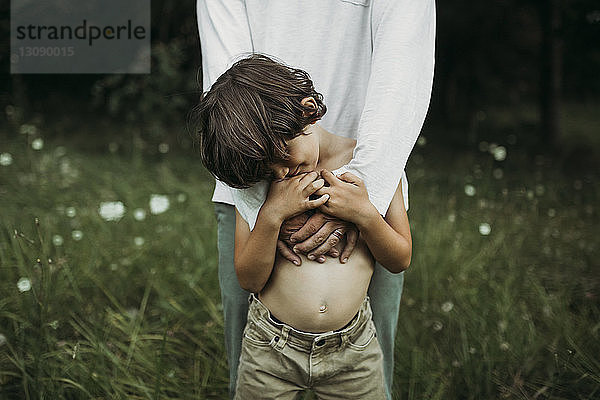 Vater und Sohn stehen auf einem Grasfeld