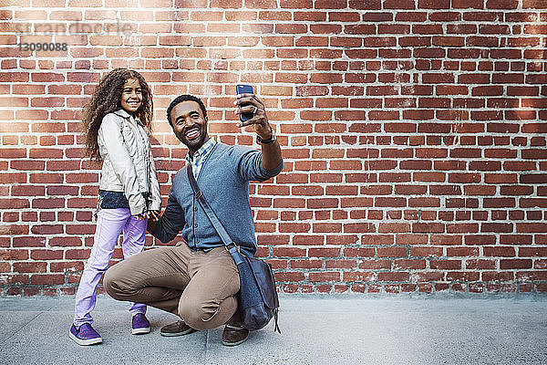 Glückliche Vater und Tochter nehmen Selbstliebe am Smartphone
