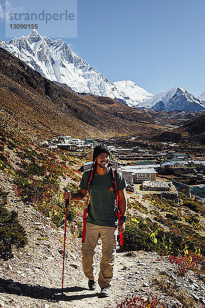 Männlicher Wanderer mit Wanderstock beim Wandern auf Berg gegen blauen Himmel im Sagarmatha-Nationalpark