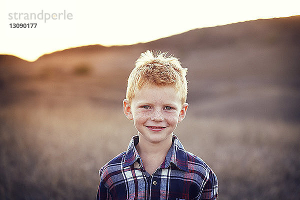 Porträt eines lächelnden Jungen auf dem Feld an einem sonnigen Tag