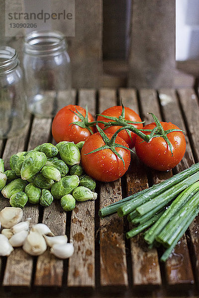 Hochwinkelansicht von Gemüse und Gläsern auf Holztisch