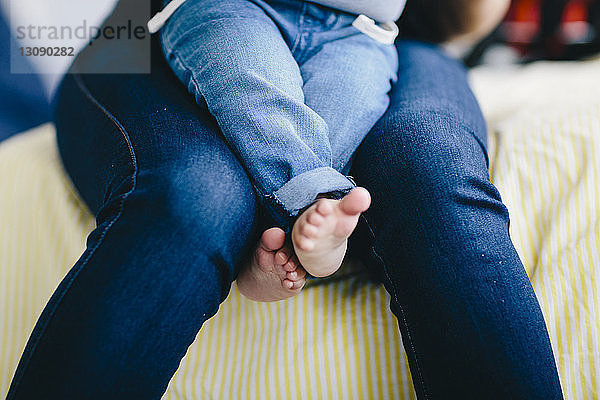 Mittendrin Mutter mit Sohn zu Hause auf dem Bett sitzend