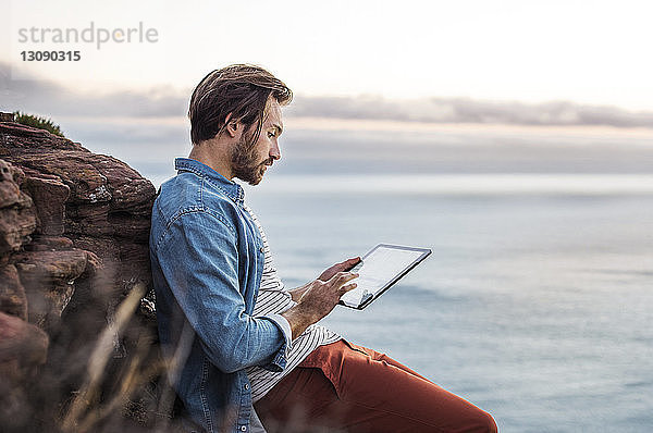 Seitenansicht des Menschen mit Tablet-Computer auf See