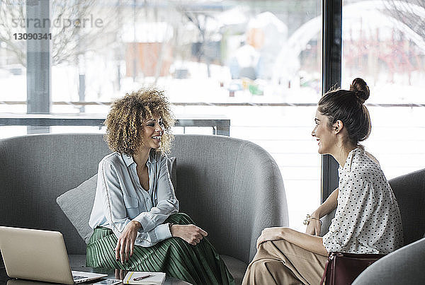 Lächelnde Geschäftsfrauen diskutieren im Restaurant