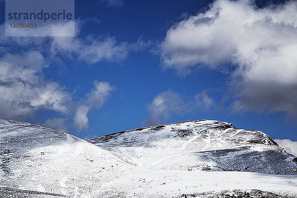 Landschaftliche Ansicht von schneebedeckten Bergen vor bewölktem Himmel