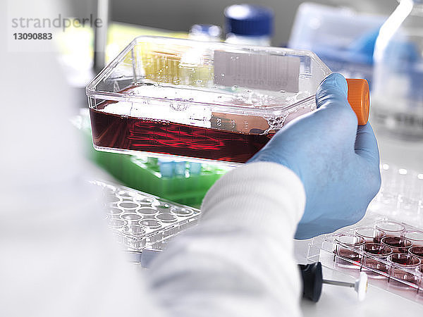 Nahaufnahme eines Labortechnikers  der eine Blutprobe in einem Behälter für medizinische Tests aufbewahrt
