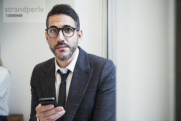 Porträt eines Geschäftsmannes beim Telefonieren im Büro
