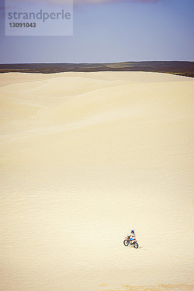 Jugendliches Mädchen fährt Fahrrad in der Wüste