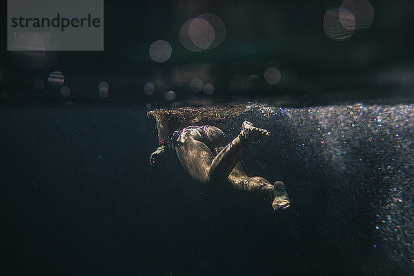 Unterwasserschwimmende junge Frau