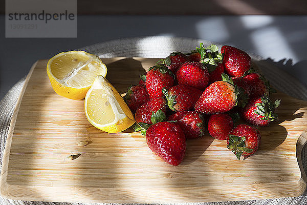 Nahaufnahme von Erdbeeren und Zitronenscheiben auf Schneidebrett