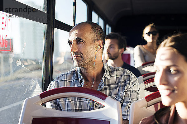 Fahrgäste  die während der Fahrt im Bus durch das Fenster schauen