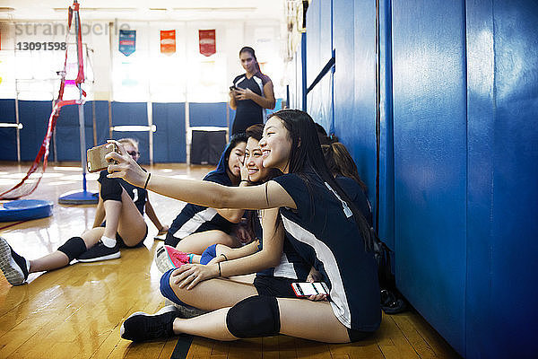 Teenager-Mädchen klicken beim Entspannen vor Gericht auf Selfie