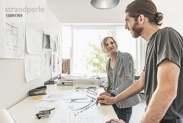 Berufstätige Männer und Frauen diskutieren im Amt