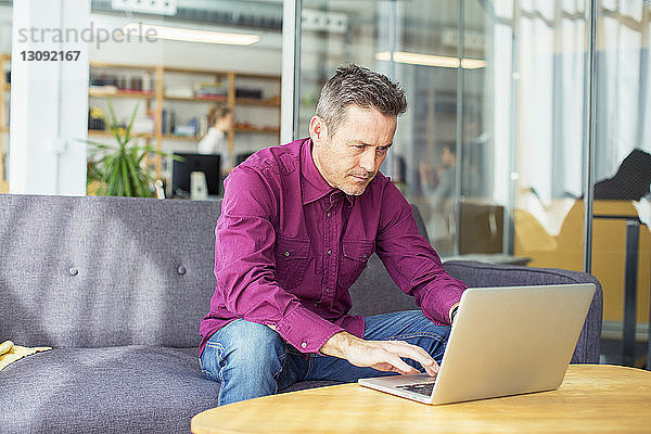 Geschäftsmann mit Laptop-Computer im Büro