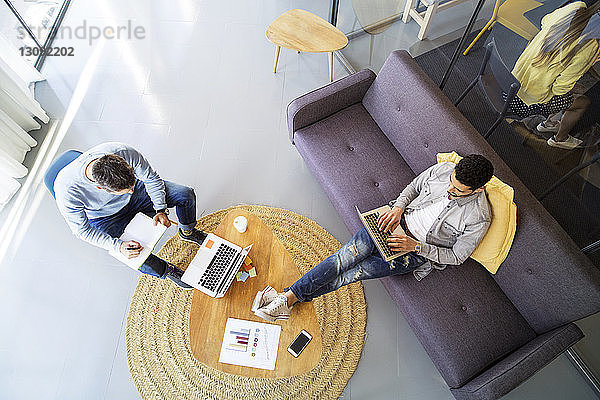 Hochwinkelansicht von männlichen Kollegen  die im Büro arbeiten