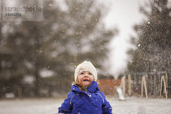 Glückliches Mädchen genießt Schneefall