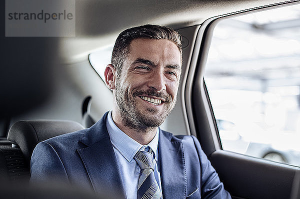 Fröhlicher Geschäftsmann sitzt im Auto