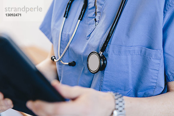 Mittelsektion einer Ärztin  die einen Tablet-Computer im Krankenhaus benutzt