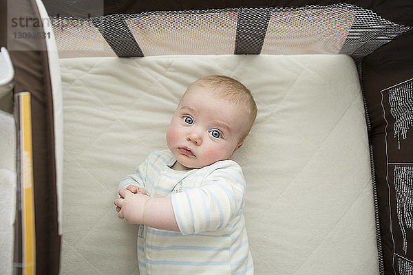 Portrait eines süßen kleinen Jungen  der zu Hause auf einer Matratze liegt