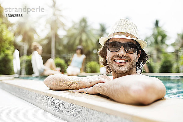 Glücklicher Mann entspannt sich im Schwimmbad eines Touristenortes