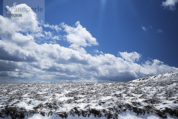 Szenische Ansicht eines schneebedeckten Berges vor bewölktem Himmel