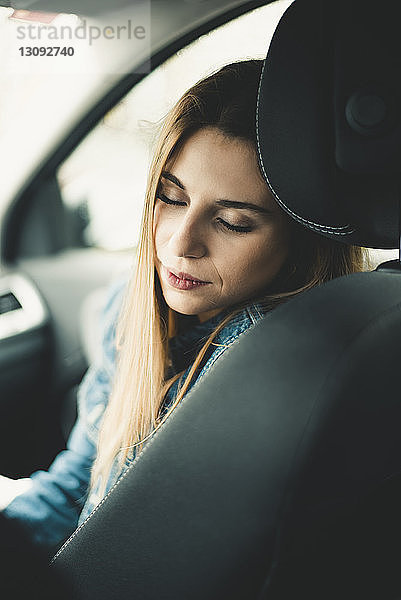 Nahaufnahme einer Frau mit geschlossenen Augen beim Entspannen im Auto