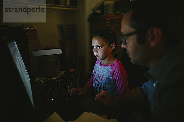 Schwere Tochter benutzt Desktop-Computer vom Vater zu Hause