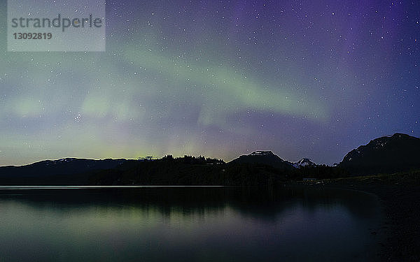 Szenische Ansicht des Nordlichts  das sich nachts in einem ruhigen See spiegelt