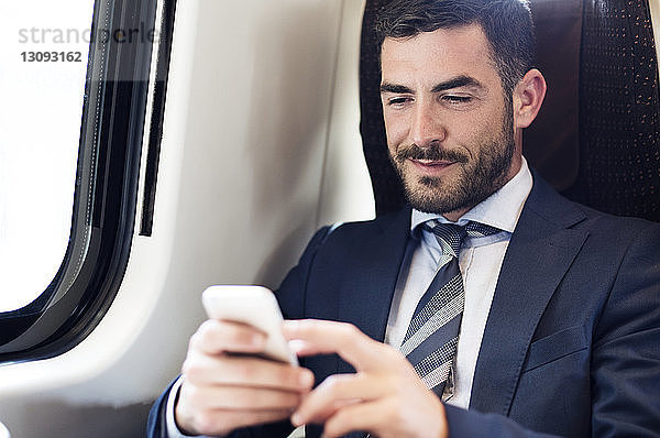 Geschäftsmann mit Smartphone im Zug